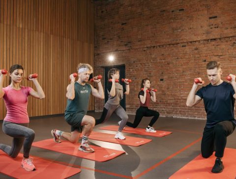 Indoor group workout session with dumbbells focusing on strength and fitness.